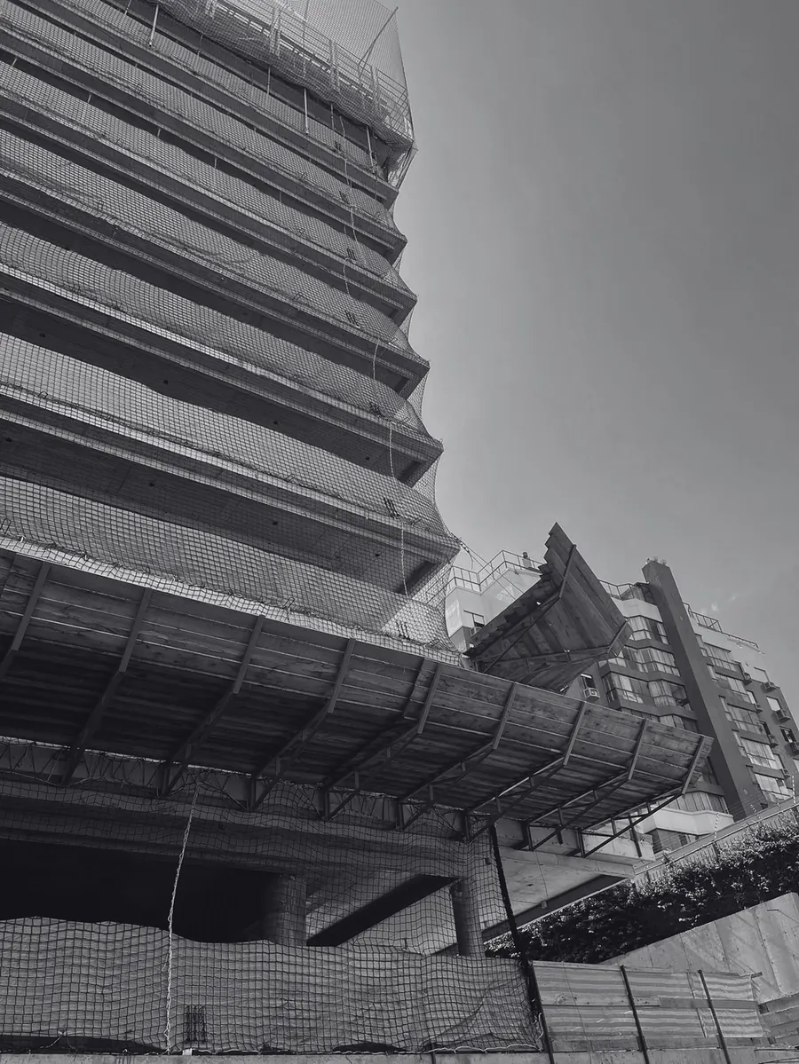 Edifício em construção com plataformas de proteção na fachada